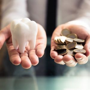 Tooth balanced with a pile of coins