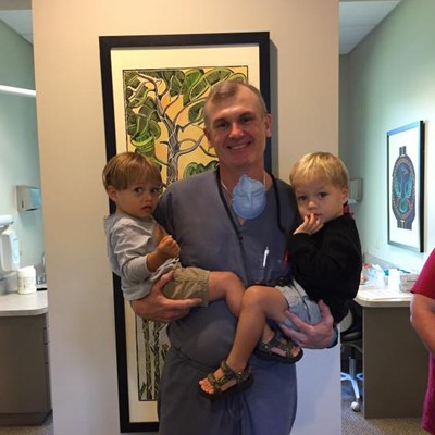 Dr. Hube Parker smiling with two young patients.