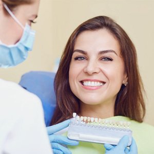 Woman smiling while dentist holds a color slide