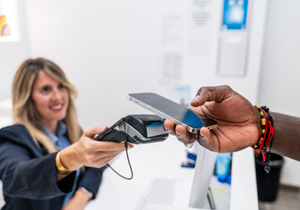A young woman paying for her dental care