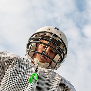 Young boy in football uniform with green mouthguard