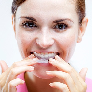 Woman placing a boil and bite mouthguard