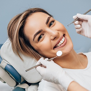 a smiling woman sitting in a dental chair