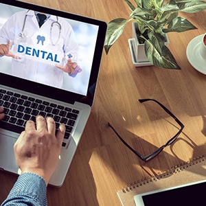 a person looking up their dental benefits on a laptop 