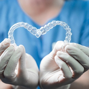 dentist holding up Invisalign aligners