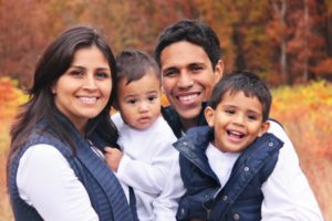 family of four hugging and smiling