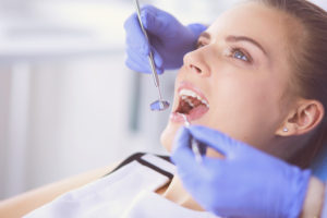 woman patient with open mouth for exam at dentist office