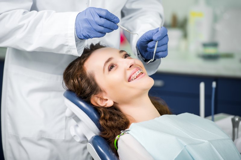 a female patient wearing braces receiving care by an orthodontist in West Mobile