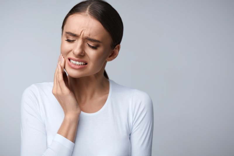 Woman with tooth sensitivity needing to see emergency dentist