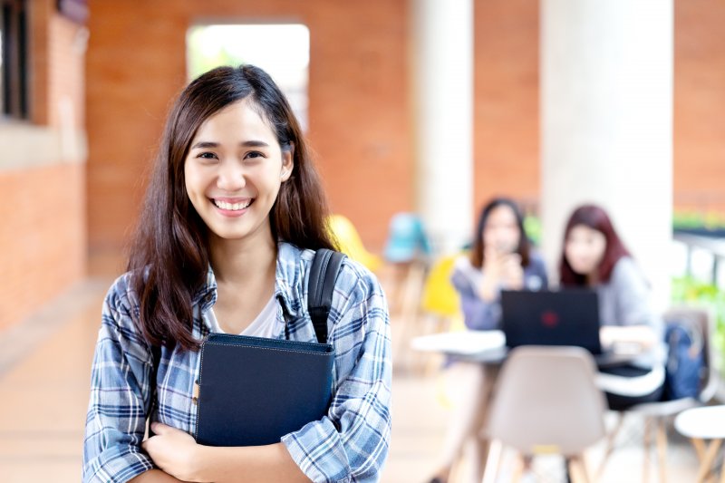 A college student smiling toward the camera